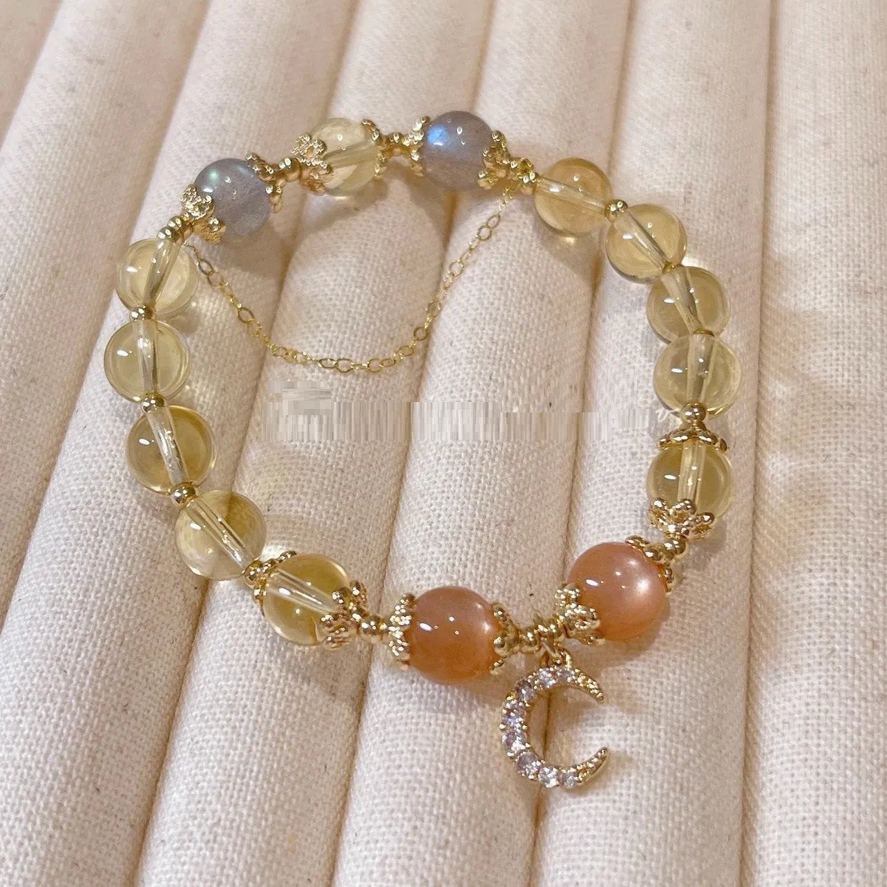 Gold electroplated women's crystal bracelet with diamond shape and fortune charm.