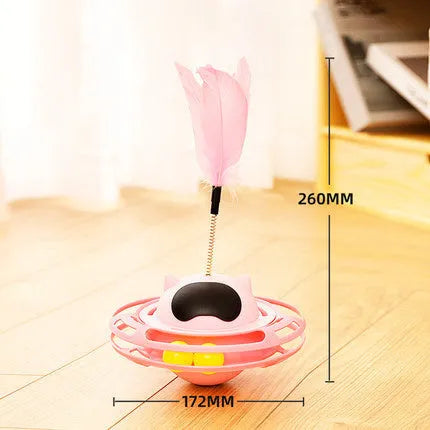 Pink plastic cat tumbler turntable toy with stick and ball on a flat surface.
