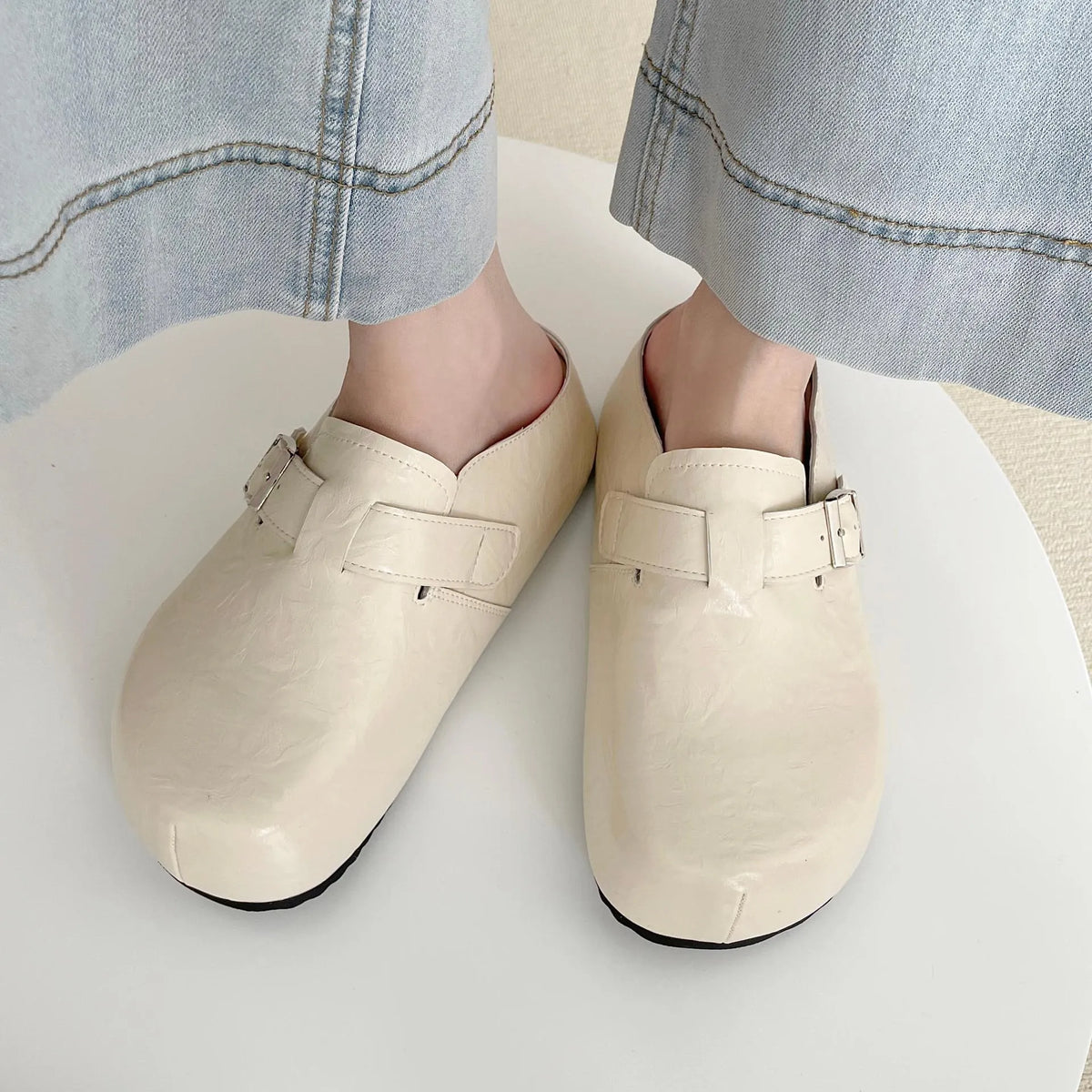 Flat buckle casual sneakers in yellow, creamy-white, silver, and black colours showing round toe and buckle detail.