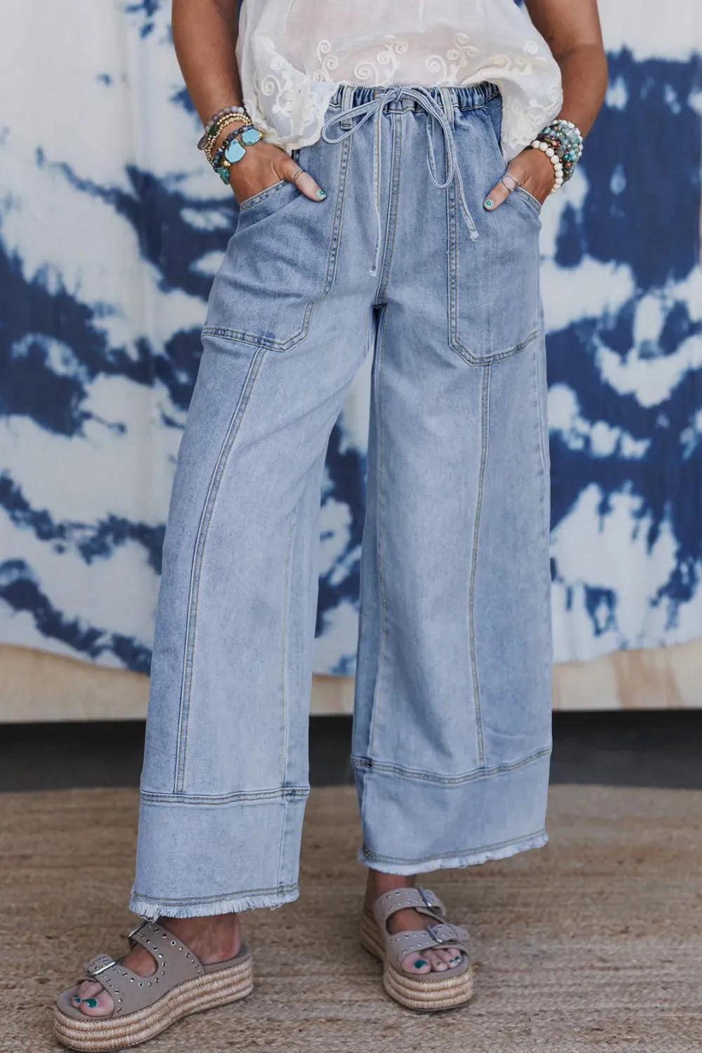 Beau blue wide leg women's denim trousers with a drawstring waist and raw hem detailing.
