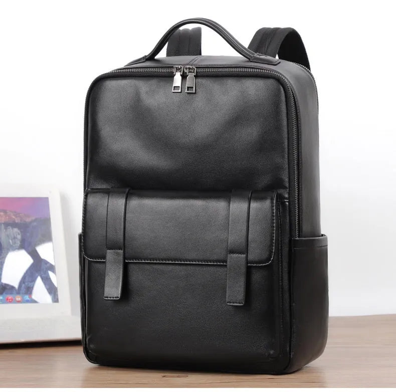 Men's black genuine leather computer backpack with curved back plate showing litchi grain texture and substantial 36-55L capacity.