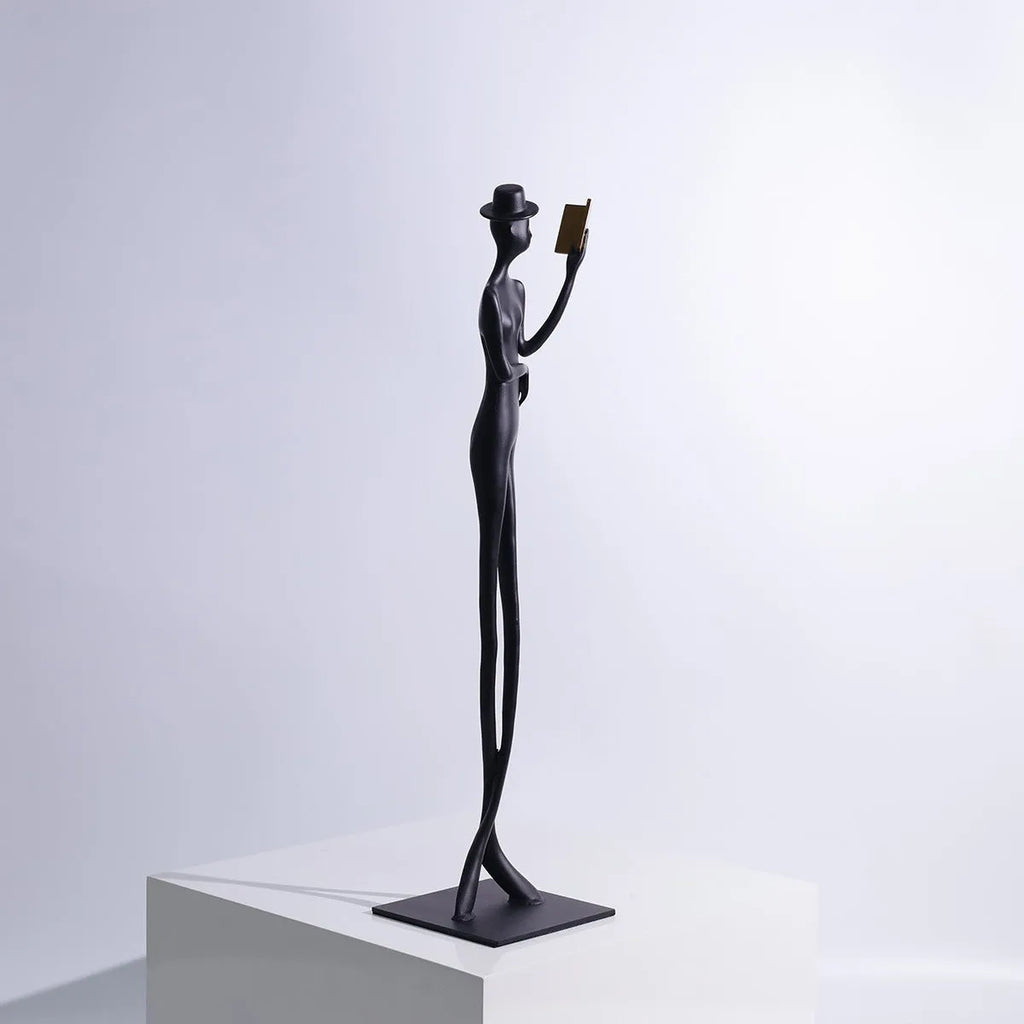 Black metal reading woman desktop sculpture made of cast aluminium measuring 51 cm tall