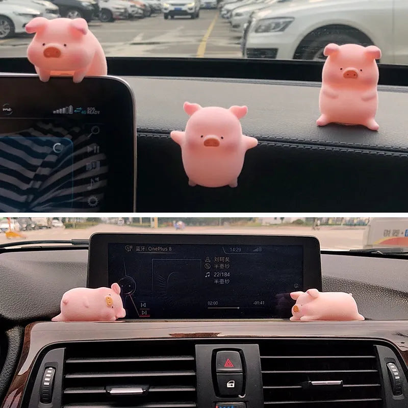 A cute resin cartoon pig figurine car dashboard decoration on a grey background.