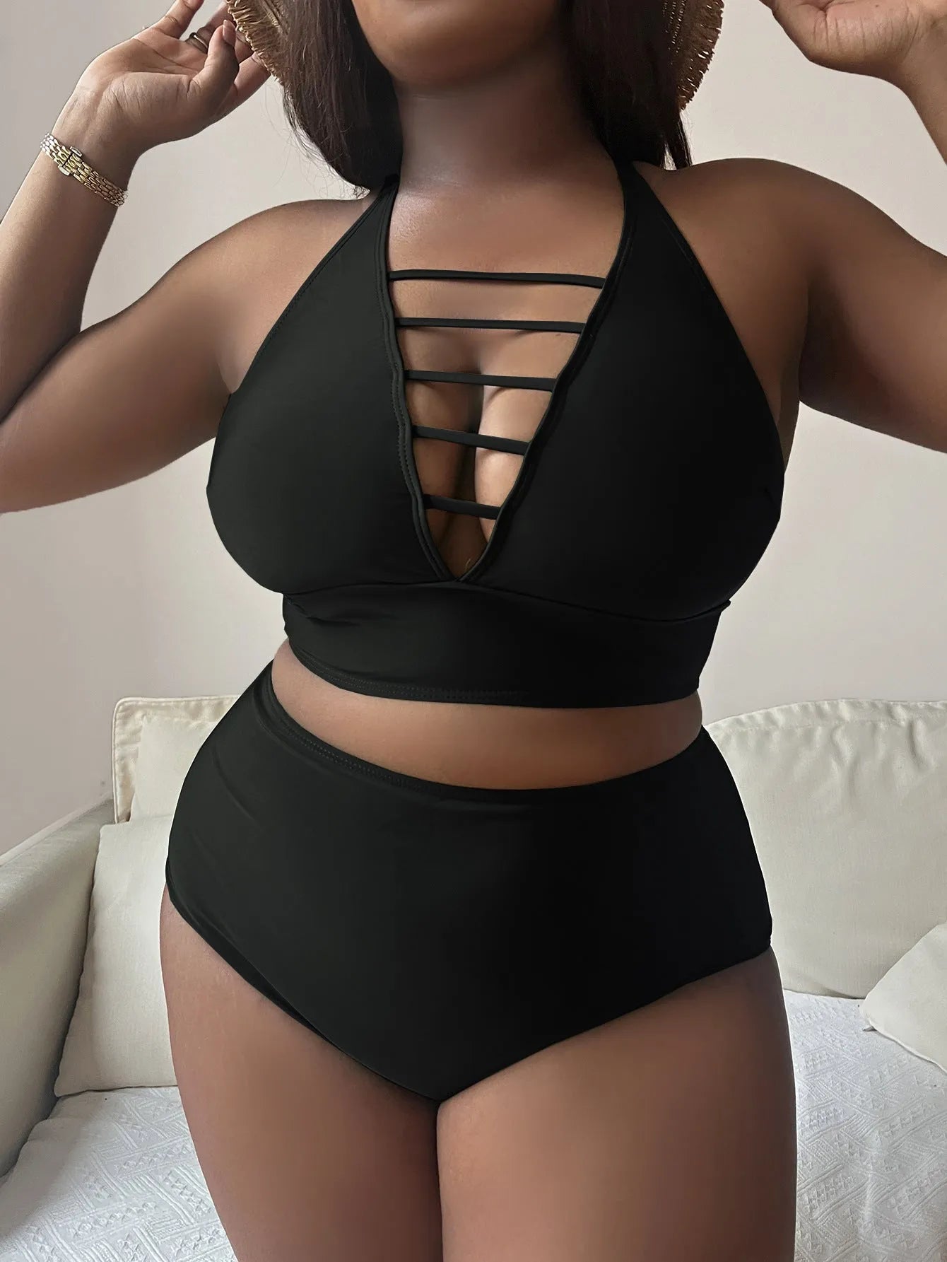 Plus-size woman in a black halter bikini with adjustable cross straps and high-waist briefs.