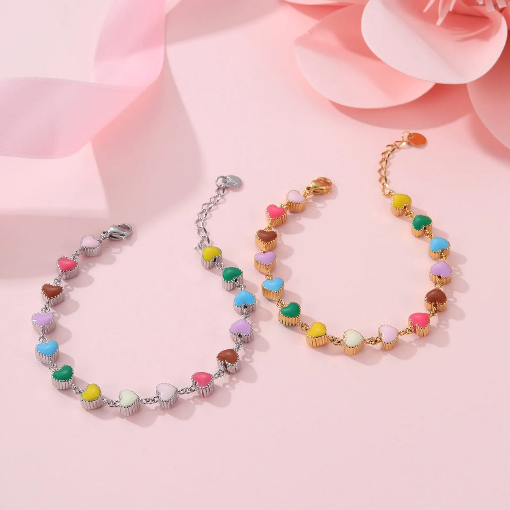 Close-up of a women's stainless steel bracelet with a colourful, heart-shaped titanium steel pendant.