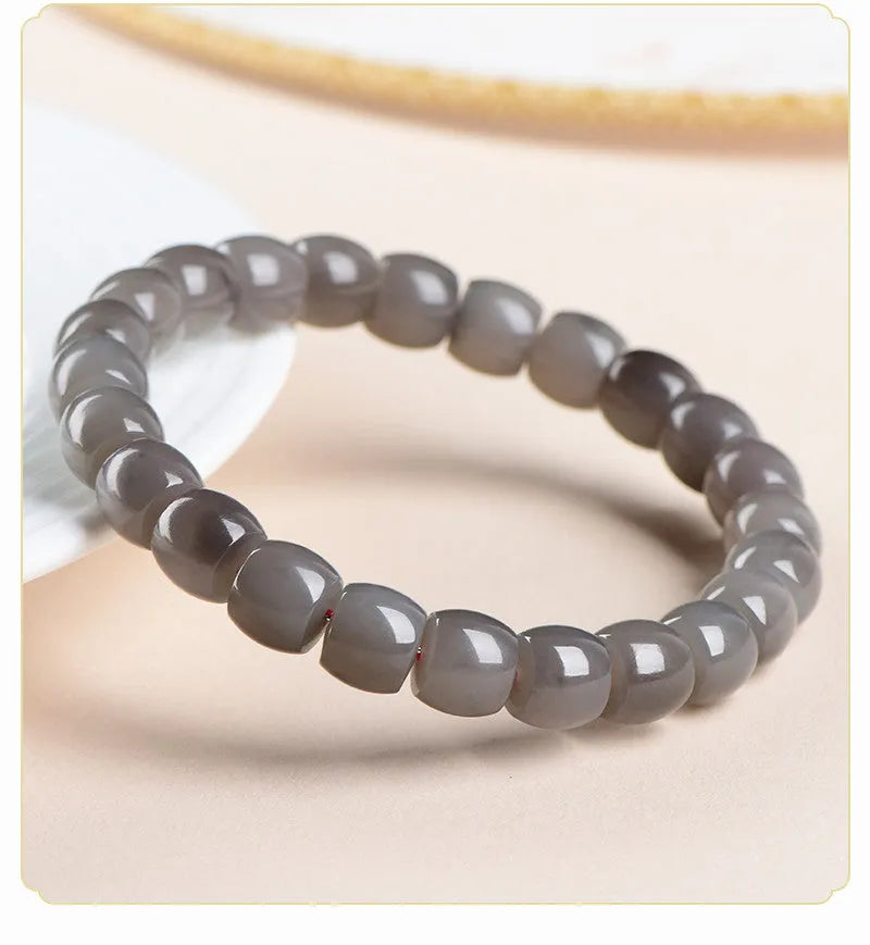 Natural smokey violet Hetian jade straight cut bracelet on a wrist.