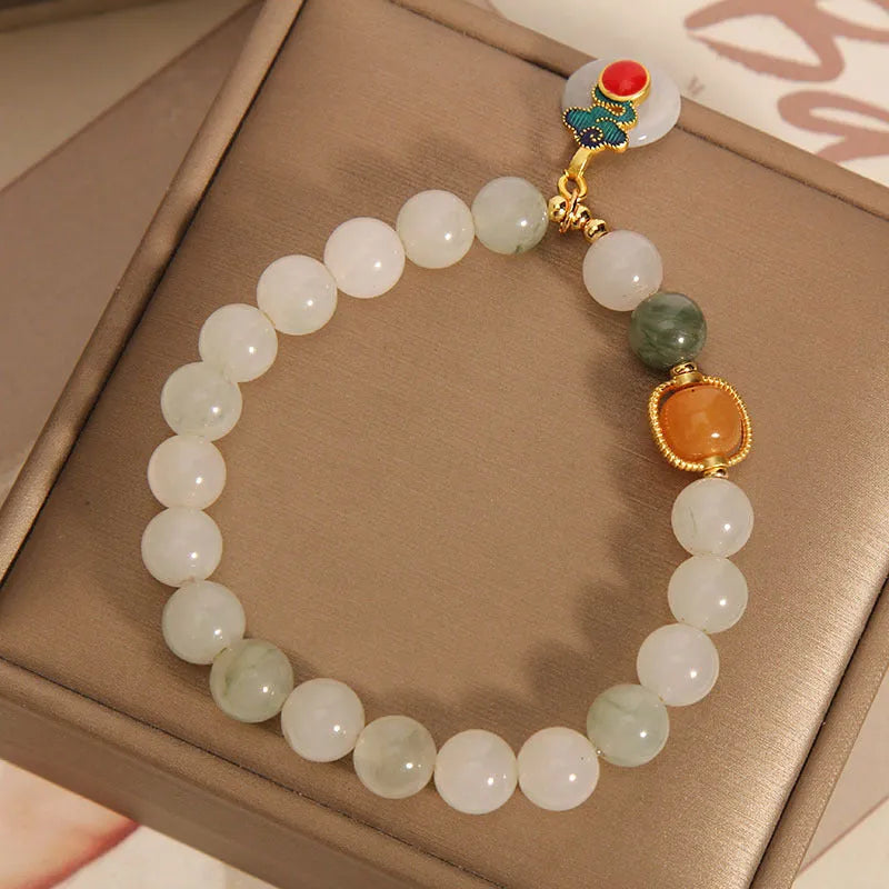 Women's ice jade crystal bracelet with pearl accents and a Xiangyun jade buckle on a white background.
