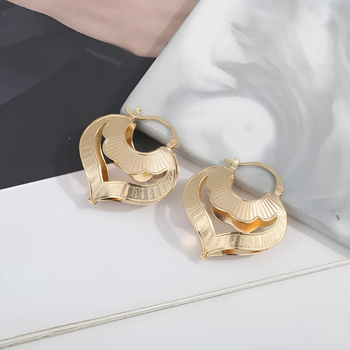 Gold electroplated copper heart-shaped hollow stud earrings with lace-inspired openwork design and geometric round elements