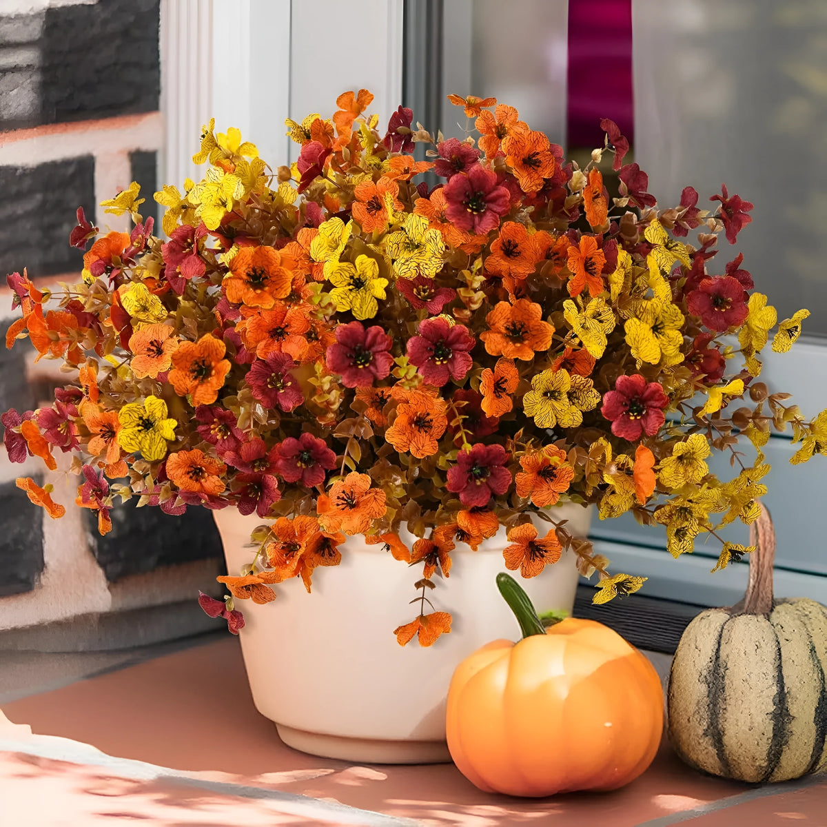 Artificial silk and plastic flower bouquet in autumn colours of red, yellow, and orange for home or wedding decoration