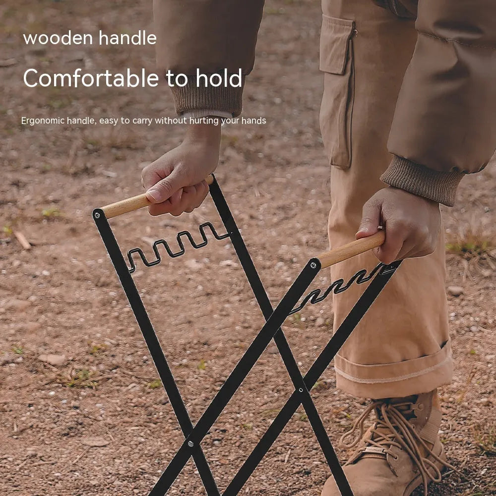 Black outdoor folding iron trash rack with wooden handle holding a rubbish bag.
