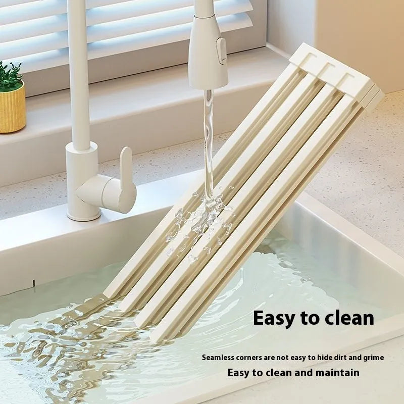 Milky white foldable stainless steel kitchen draining rack over a sink.