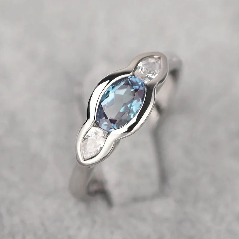 Geometric ellipse-shaped women's ring with zircon inlay in a white gold finish, shown on a hand.