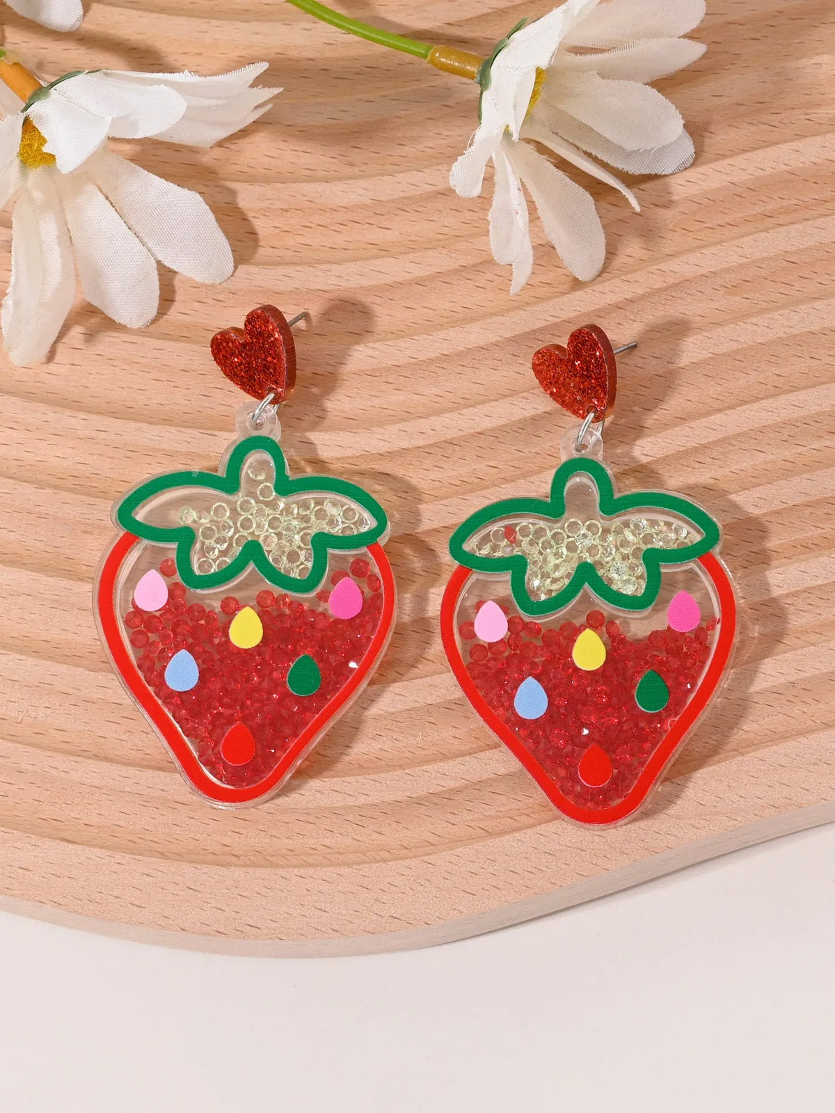 Acrylic drop earrings shaped like a strawberry, cherry, watermelon, pineapple, cake, ice cream, and coconut tree on a white background.