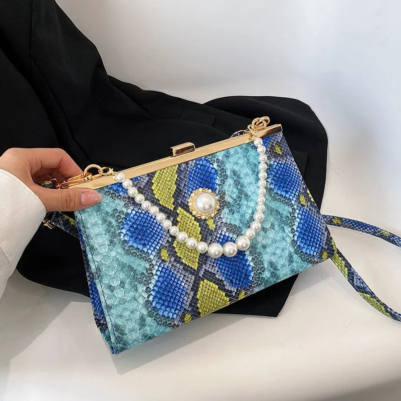 Hard PU evening bag in snake pattern with pearl-chain detail and stitching, available in six colours