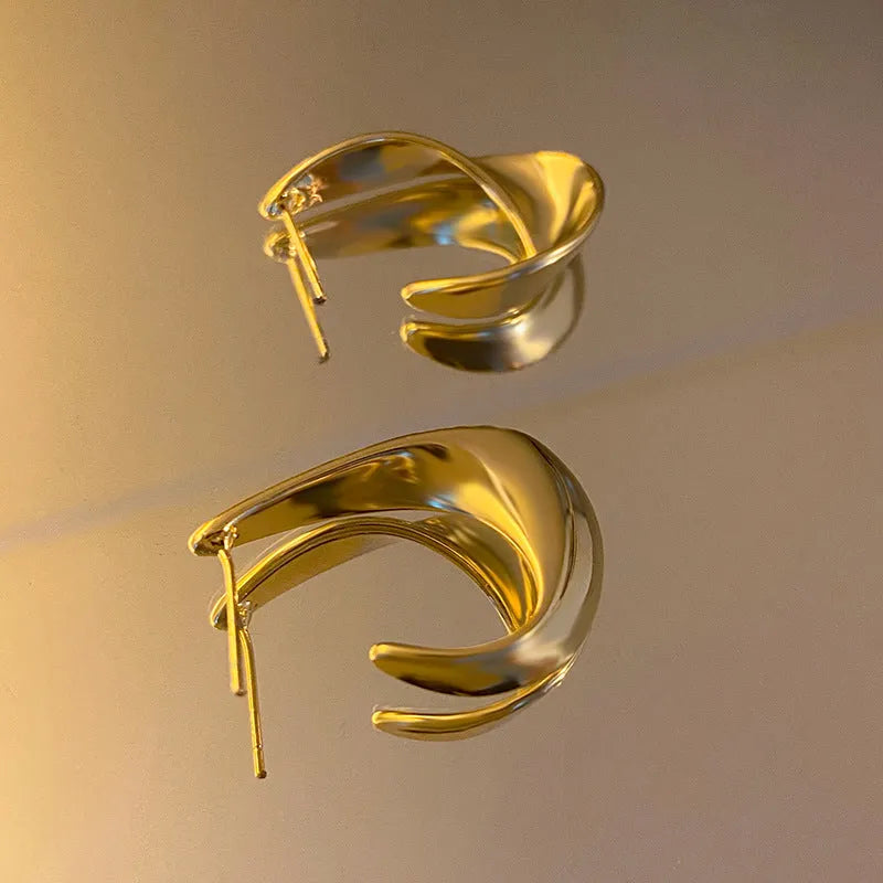 Twisted geometric metal earrings with circular elements in gold or silver electroplated finish
