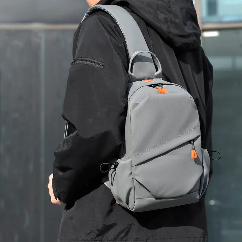 A black polyester single shoulder crossbody bag for men, shown with a model wearing it.
