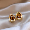 Three pairs of handmade holiday ear rings in geometric designs with tassel elements