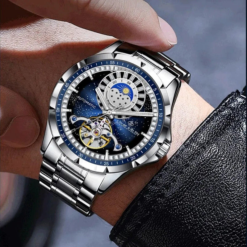 Silver automatic mechanical watch with blue dial and stainless steel bracelet on wrist