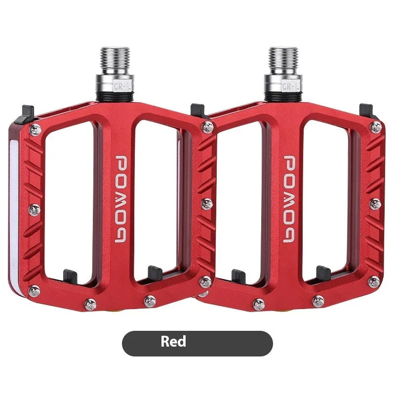 Aluminium alloy bicycle pedals with 710 LED lights in purple, black, titanium, red, and gold colours.