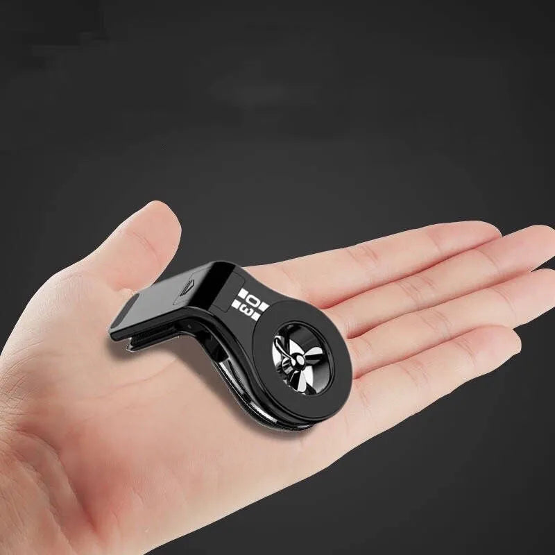 Black magnetic car phone holder clipped to car air vent with smartphone attached and fragrance pads
