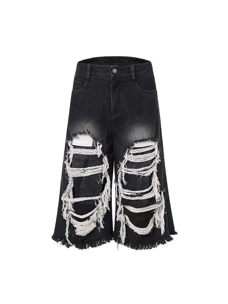 Women's black cropped wide-leg jeans with distressed patch details and mid-high waist