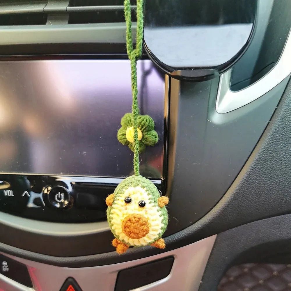 Handmade crocheted car pendant featuring a colourful avocado and rainbow flower design in wool yarn.