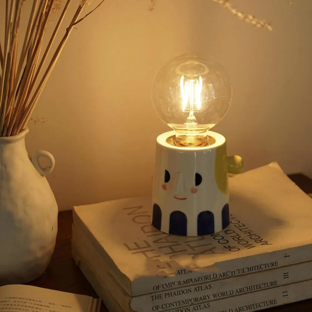 Handmade ceramic table lamp with a spherical ball headlight shape on a stand.