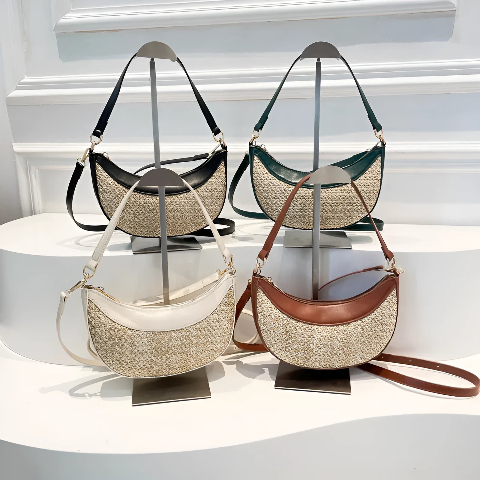 Hard straw women's crossbody dumpling bag in black with contrast stitching and single shoulder strap.