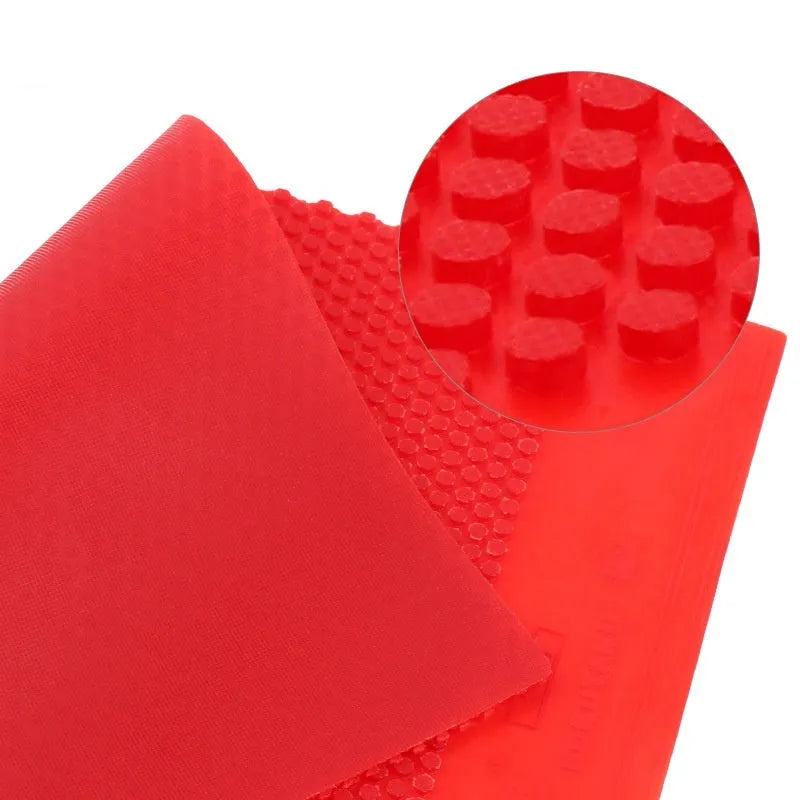 Single sheet of black and red raw rubber for table tennis rackets with small particle texture.