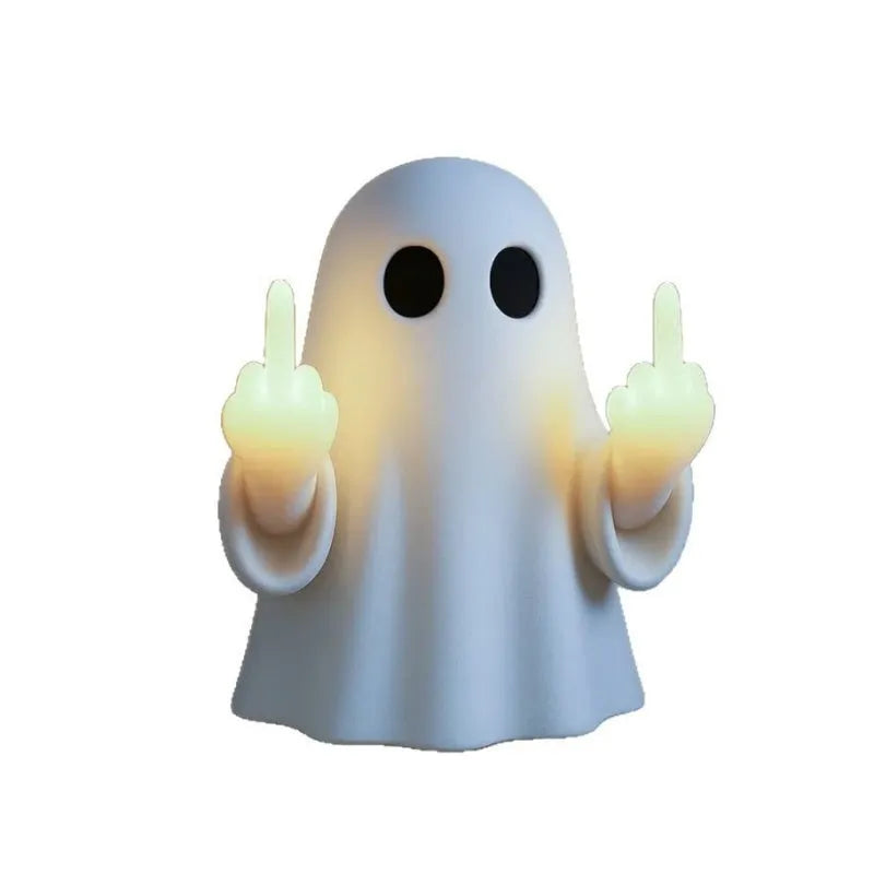 White ghost statue night lamp with LED light on a dark table.
