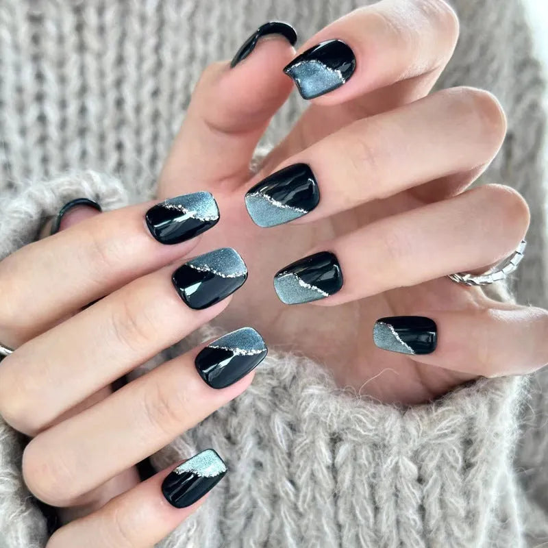Pack of false nails with assorted nail art designs and adhesive tabs for temporary wear.