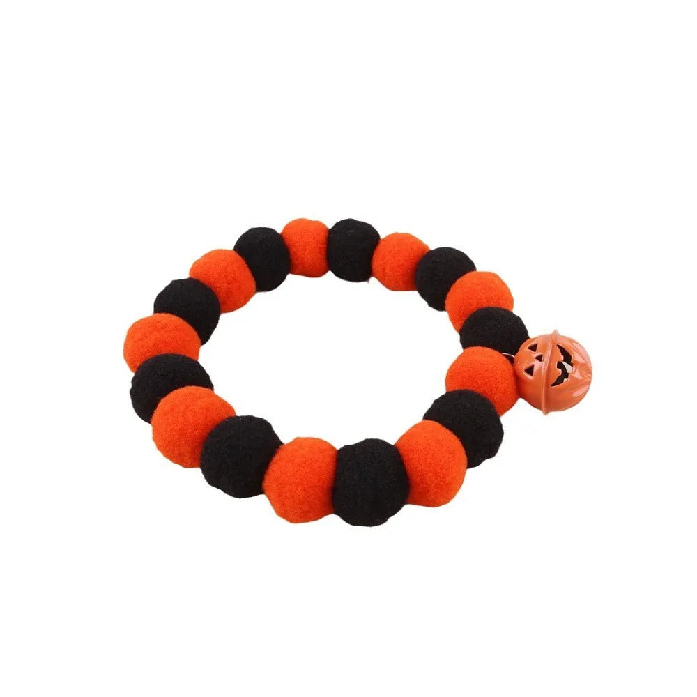 Orange Halloween cat collar with pumpkin print, breakaway buckle, and bell on a fabric band.