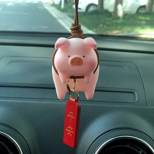 A cute resin cartoon pig figurine car dashboard decoration on a grey background.