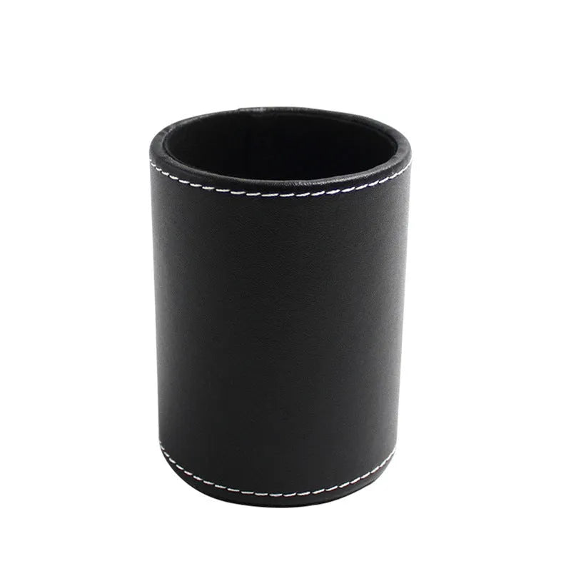 Small round black leather pen container on desk with pens inside