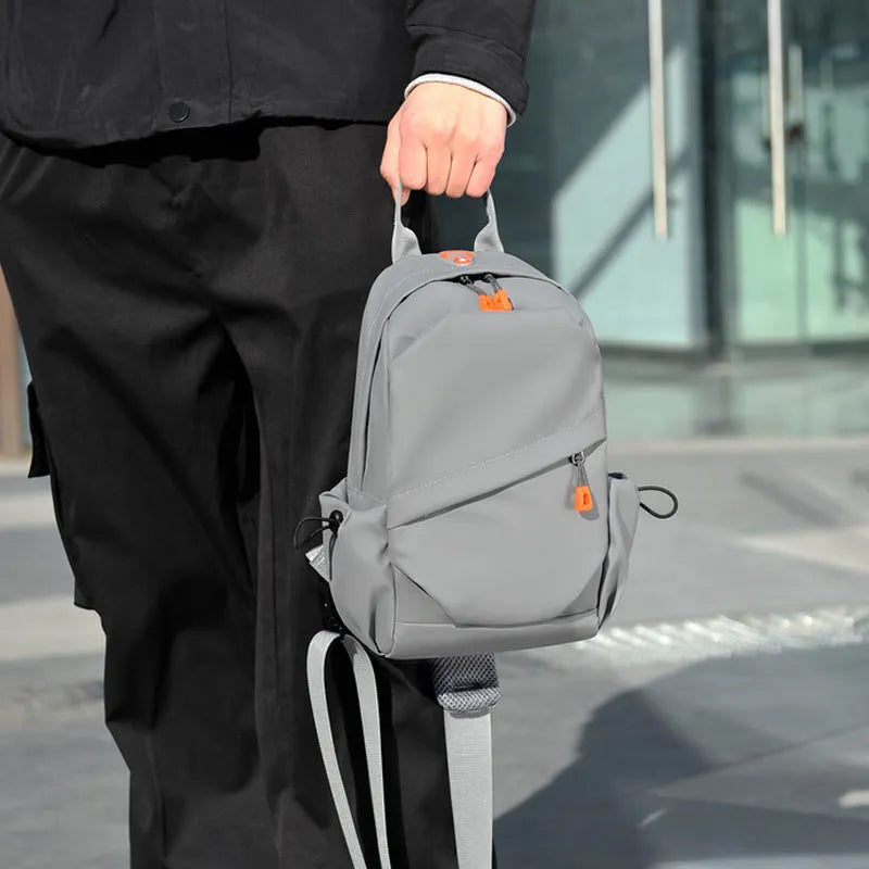 A black polyester single shoulder crossbody bag for men, shown with a model wearing it.