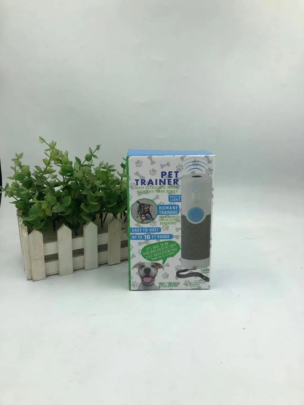 White handheld ultrasonic dog bark training device on a white background.