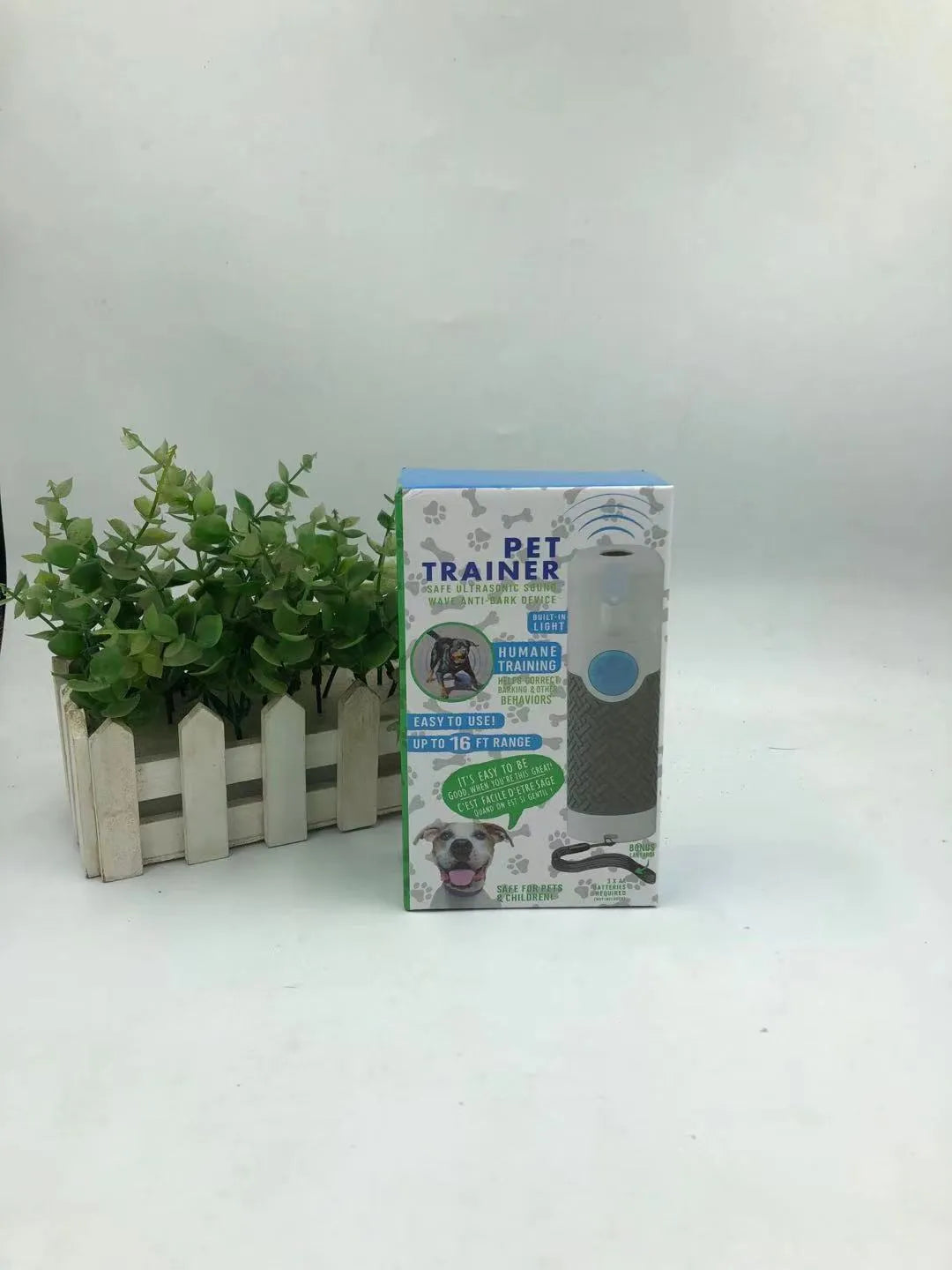 White handheld ultrasonic dog bark training device on a white background.
