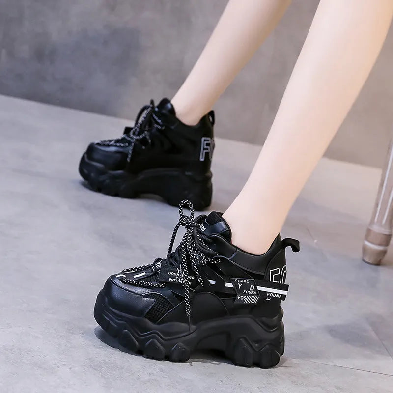 Women's white mesh platform trainers with cross-strap and chunky rubber sole on a neutral background.