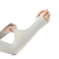 A person wearing a light grey nylon sun protection oversleeve on their arm with open fingers, suitable for driving.
