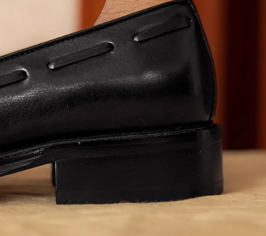 Men's black genuine leather slip-on loafers with fringe detail and rubber sole.