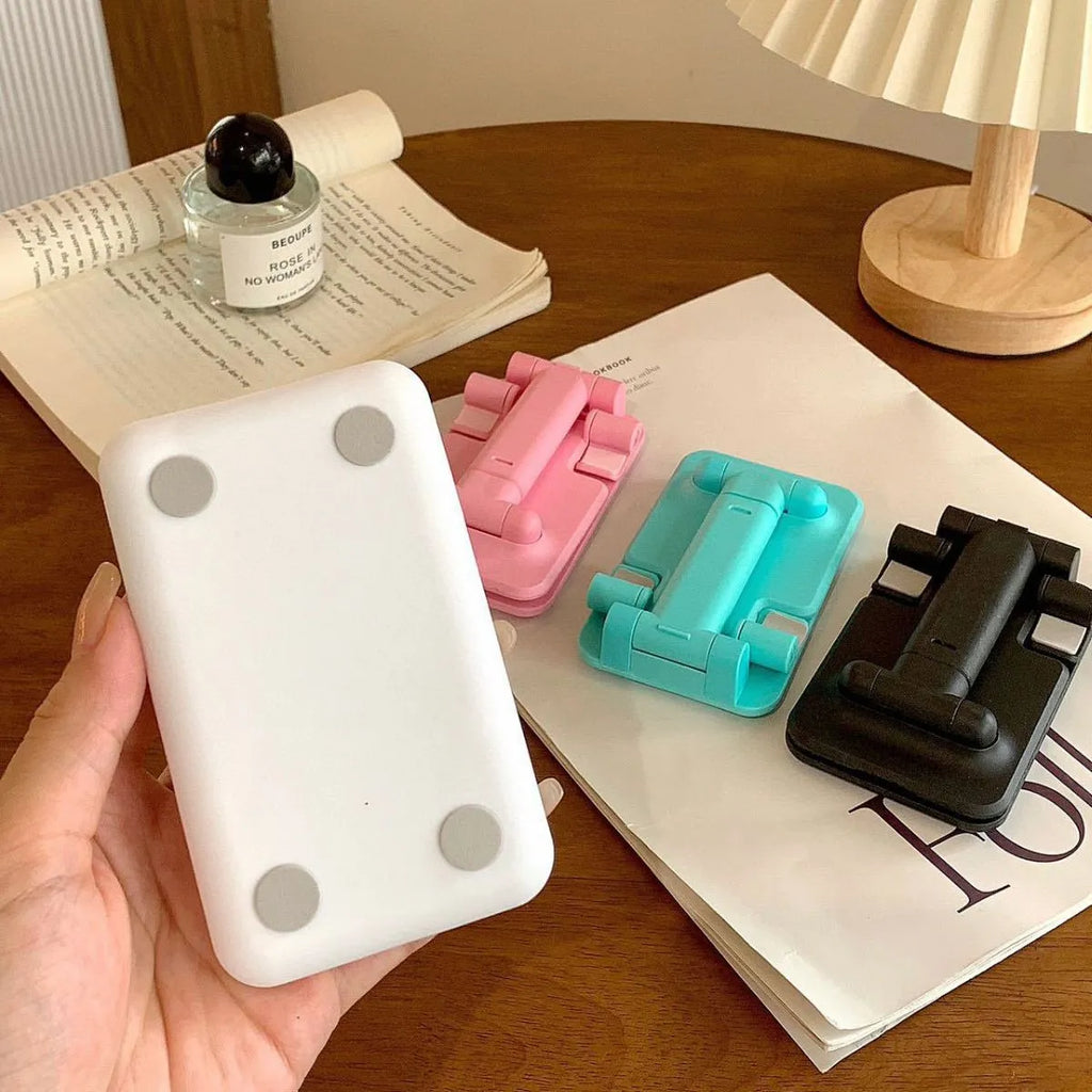 Folding universal plastic mobile phone stand in pearl white, deep black, mint green, and girl pink