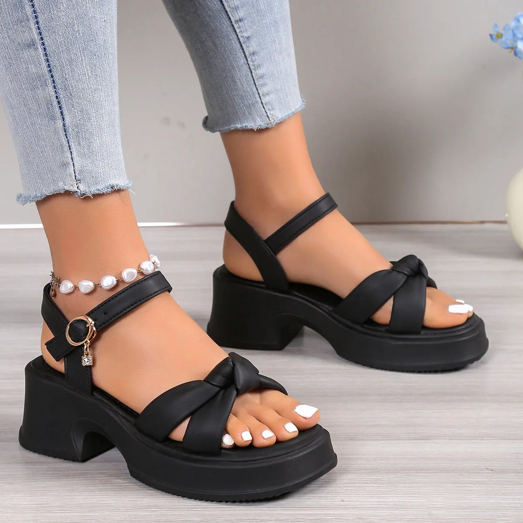 Black women's high heel slippers with thick platform sole and button closure.