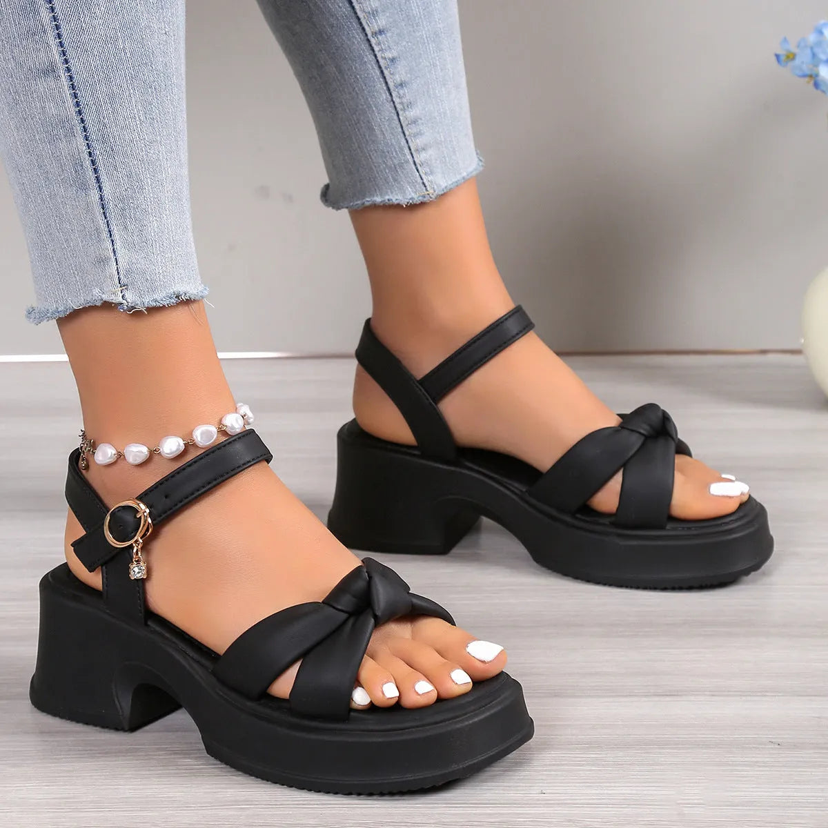 Black women's high heel slippers with thick platform sole and button closure.