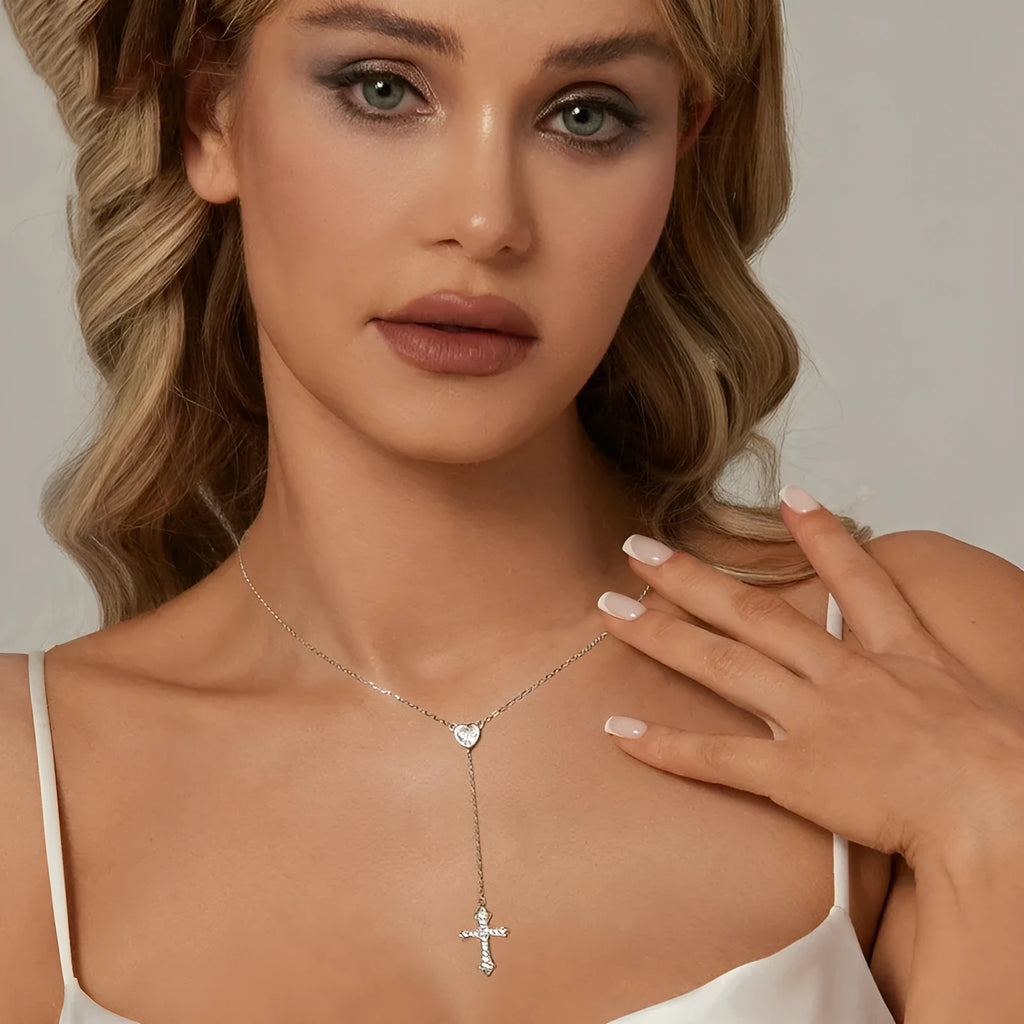 Simple silver love cross necklace on a V-neck O-ring chain for women.
