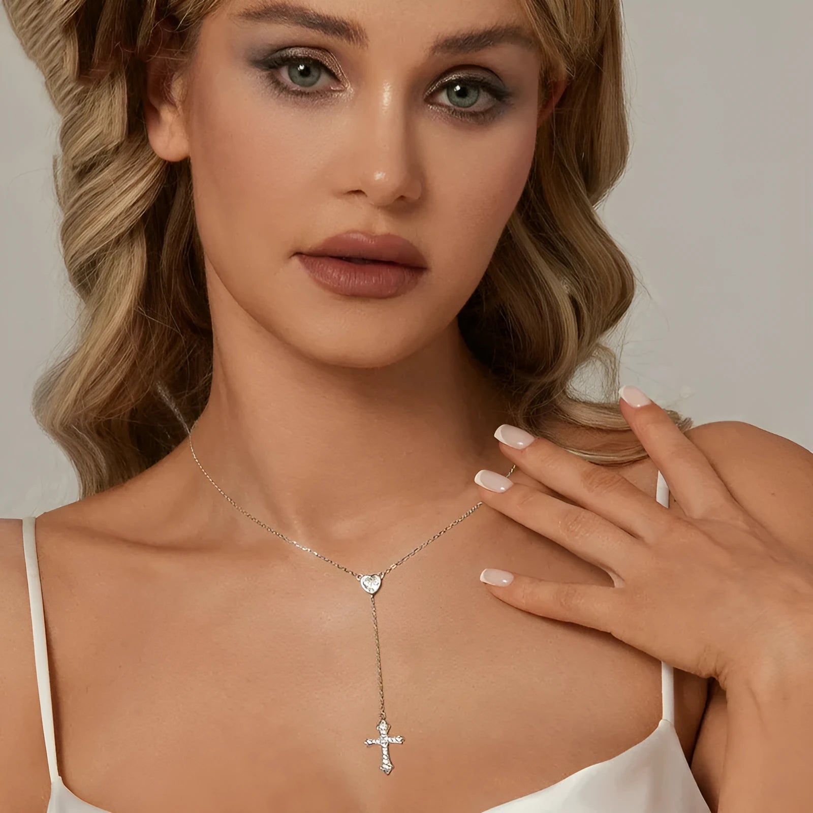 Simple silver love cross necklace on a V-neck O-ring chain for women.