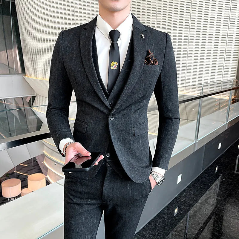 Men's slim fit black business suit jacket and trousers on a hanger.