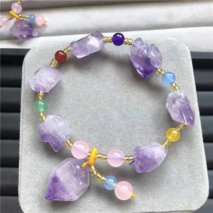 Natural shaped amethyst bead bracelet with a fu character charm on a white background