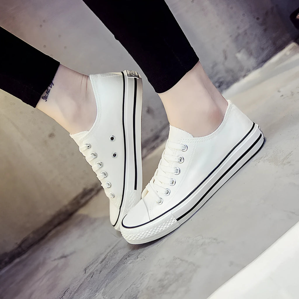 Women's solid colour canvas casual shoes showing available colours: all-black, black, white-black, and white-red.
