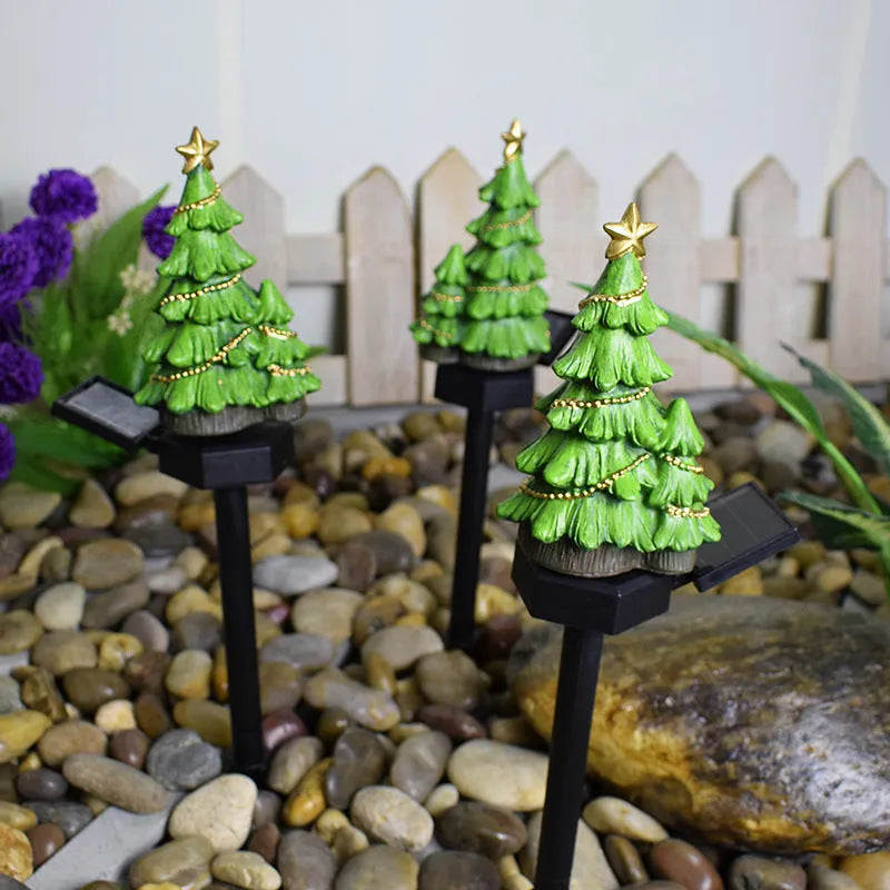 Solar Christmas tree ground plug light with warm white LED, resin body and 40 x 40mm solar panel for outdoor garden use.