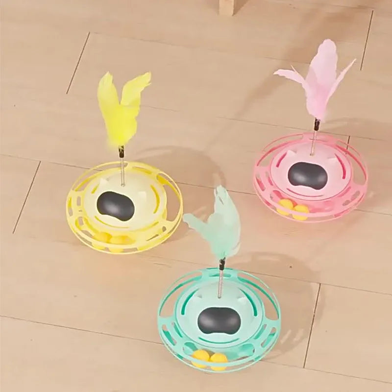 Pink plastic cat tumbler turntable toy with stick and ball on a flat surface.